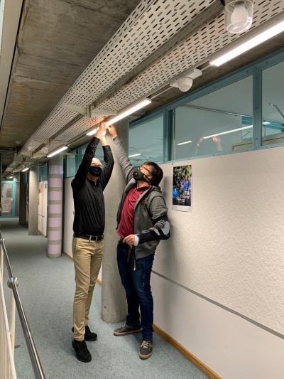 Bürgermeister Karl Langensteiner-Schönborn und Patrick Reißner vom Hochbauamt setzen eine neue LED-Deckenleuchte ein.