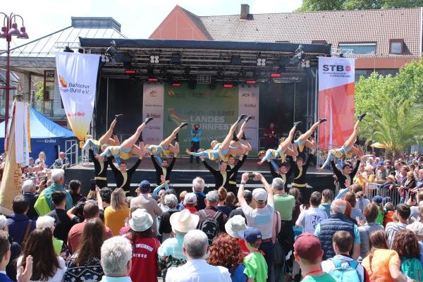 Turner auf einer Bühne, im Vordergrund Publikum