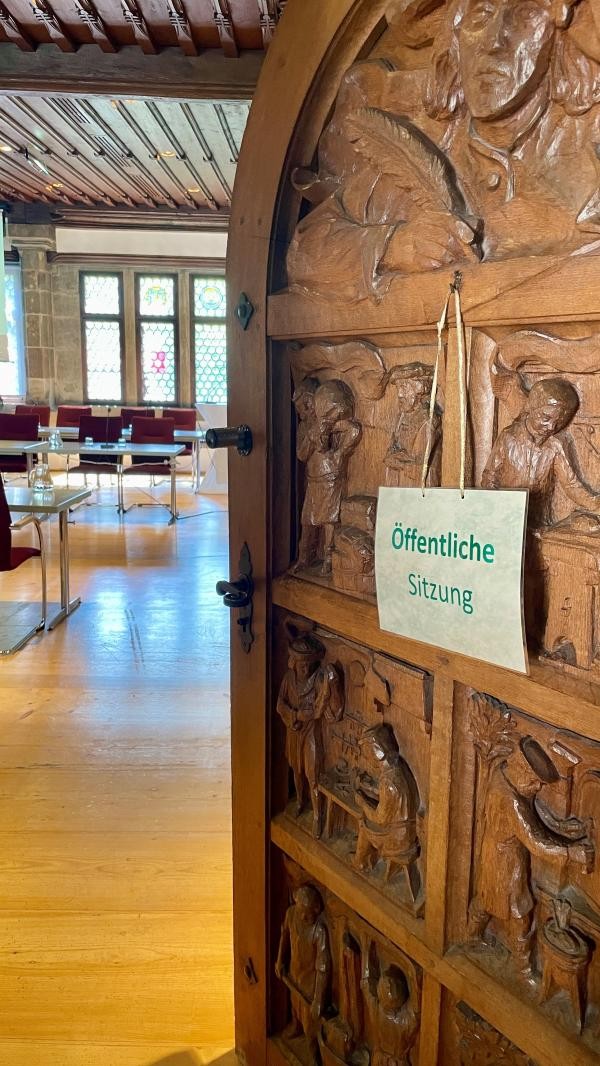 Eingangstüre Ratssaal, daran ein Schild öffentliche Sitzung