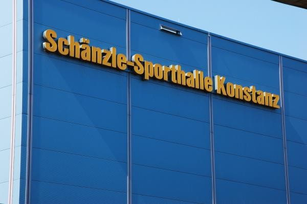 Bild eines blauen Gebäudes mit gelber Aufschrift "Schänzle-Sporthalle Konstanz"