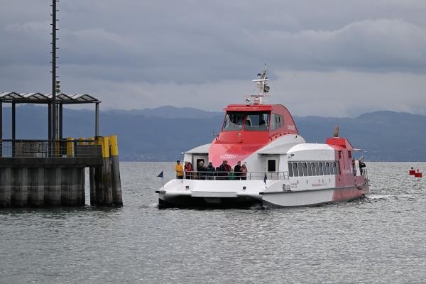 Rot-weißer Katamaran neben einer Anlegestelle auf dem See