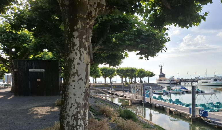 Ansicht Kassenhäusschen des Gondelhafens mit Mietbooten und der Imperia im Hintergrund