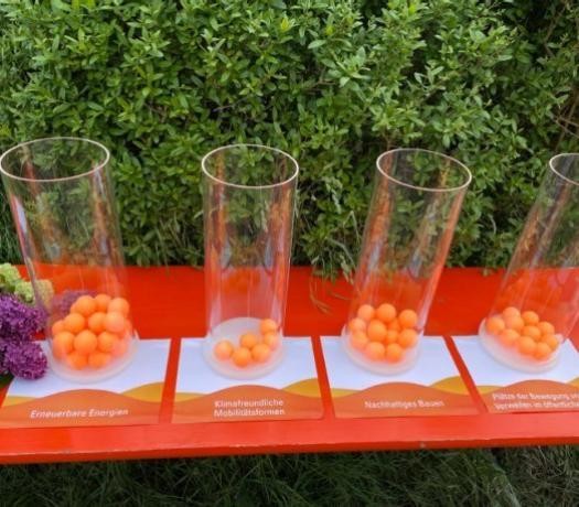 Transparente zylinderförmige Behälter, unterschiedlich gefüllt mit orangenen Tennisbällen