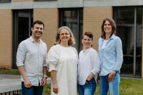 Vier Personen stehen vor einem Gebäude