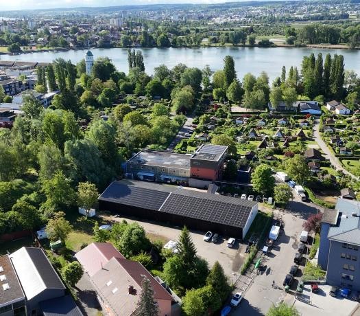 Blick auf das Dach einer Lagerhalle, das mit Photovoltaik-Modulen belegt ist