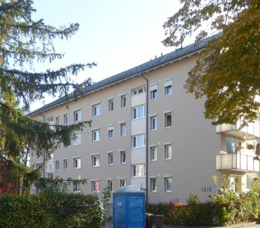 Mehrfamilienhaus mit ocker-gelber Fassade und Balkonen