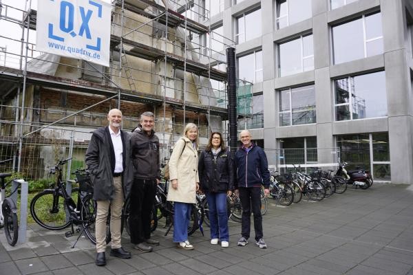 Mehrere Personen vor einem eingerüsteten Haus