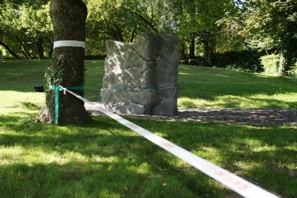 Grüne Wiese und ein Seil ist zwischen zwei Bäumen gespannt, allerdings ist nur ein Baum im Bild zu sehen