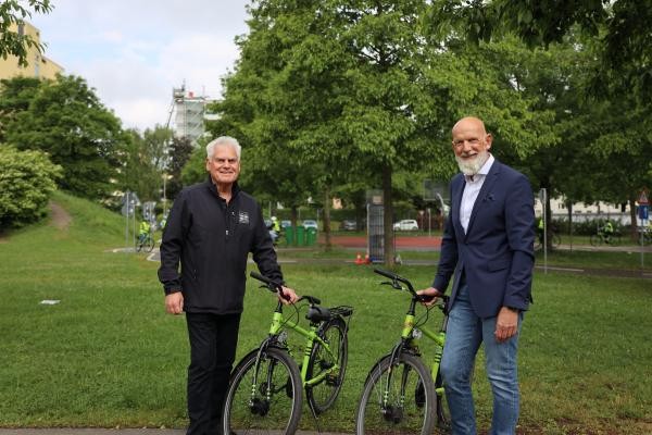Zwei Männer stehen neben zwei Fahrrädern