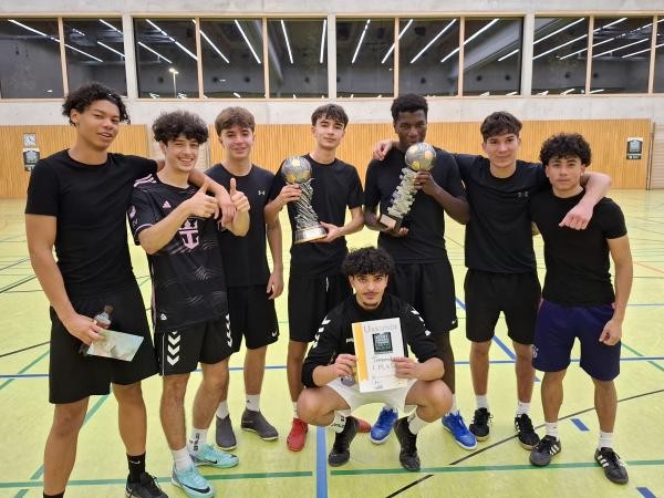 Copyright Stadt Konstanz Sieben junge Männer stehen Arm in Arm in einer Reihe, zwei davon halten einen Pokal, einer ist vorne in der Hocke und hält die Urkunde hoch