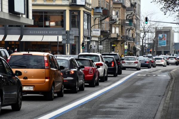 Stau in der Konstanzer Innenstadt: Mehrere Autos stehen dicht an dicht auf einer mehrspurigen Stadtstraße. Rechts ist eine mit blauer Linie markierte Busspur zu sehen. Im Hintergrund sind Geschäfte, ein Hotel und eine Ampel bei Grün erkennbar.