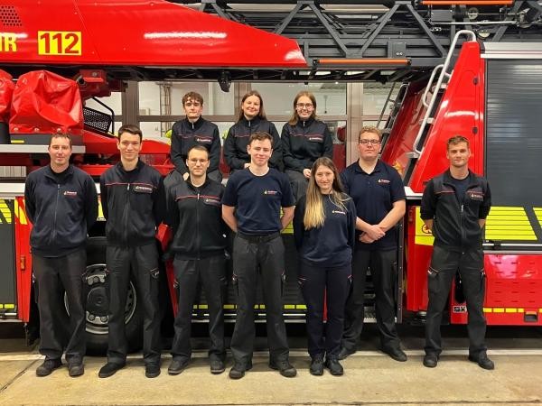 10 junge Feuerwehrleute vor einem Feuerwehrauto