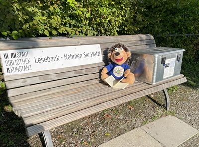 Lesebank im Stadtgarten Konstanz mit dem Kuscheltier-Maskottchen Konstantin und der Bücherkiste