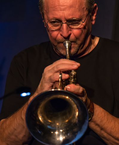 Bild von Tom Banholzer beim Spielen eines Blechblasinstruments.