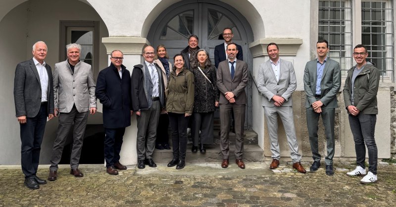 Mehrere Personen stehen vor einem Haus neben Plakaten
