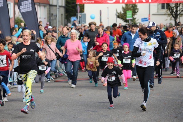 Kinder und Erwachsene mit Startnummern bei einem Stadtlauf