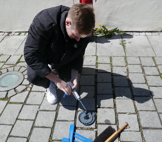 Ein Mann bringt Klebstoff auf einen Parksensor auf
