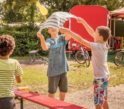 Spielende Kinder vor einem Bauwagen