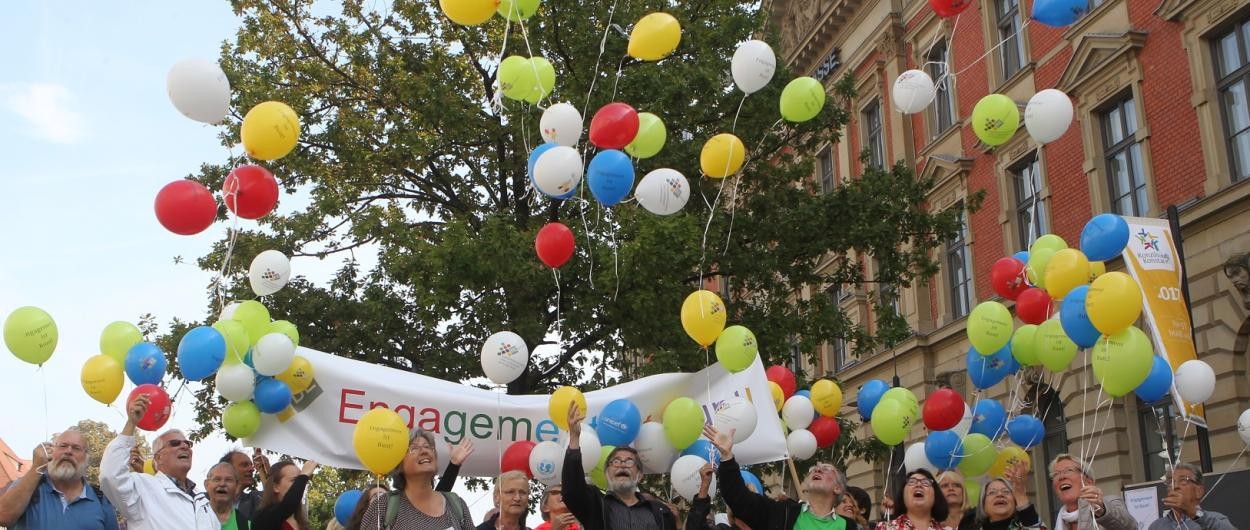 Eine Menschenmenge lässt Luftballons aufsteigen