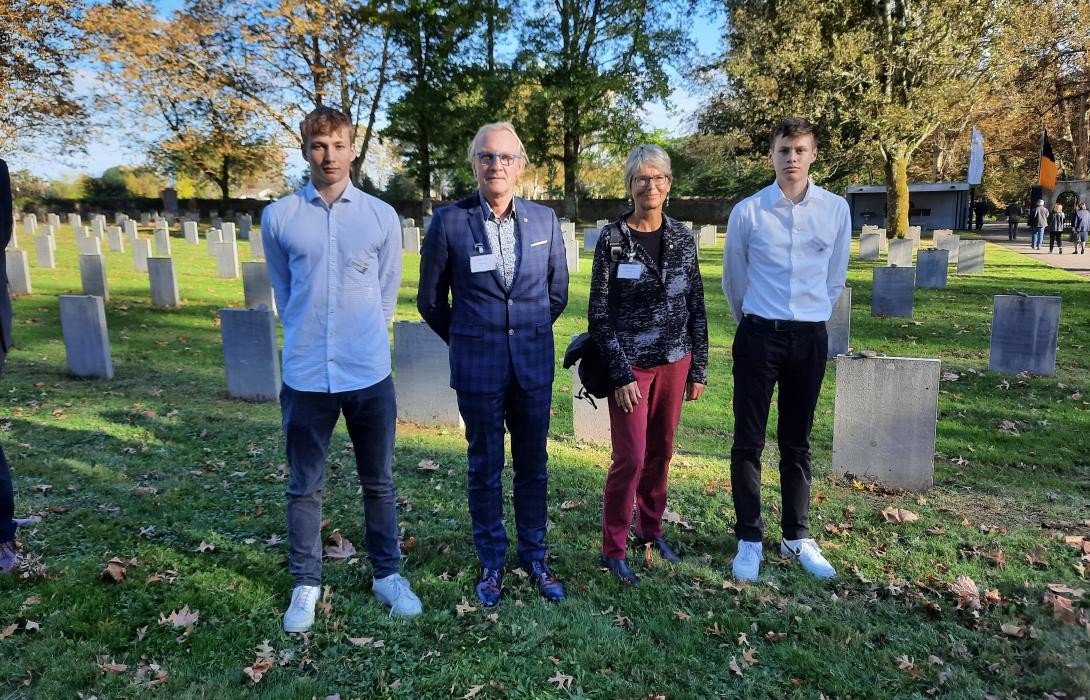 Eine vier Personen stehen vor einem Grabfeld