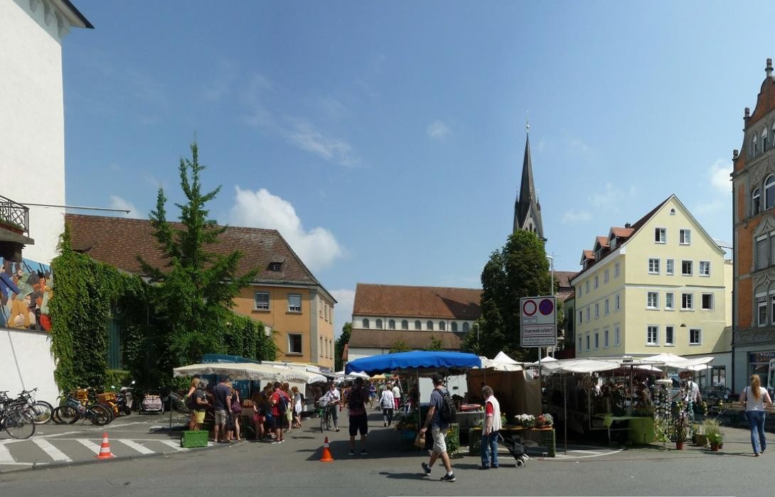 Wochenmarkt auf einem von Häusern umgebenen Platz
