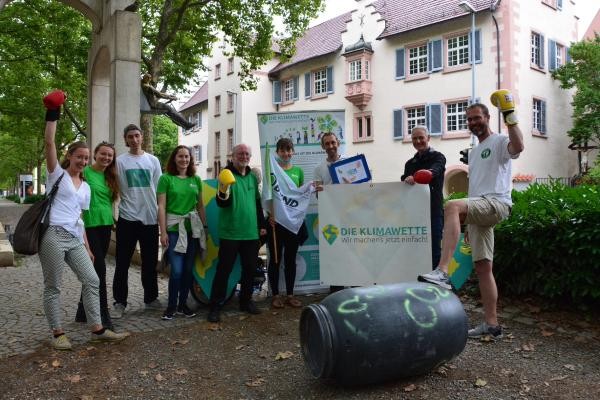 Bürgermeister Langensteiner-Schönborn hält mit Michael Bilharz das Plakat. VertreterInnen der Stadtverwaltung, BUND und Fridays for Future unterstützen die Klimawette.