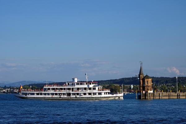 Ein weißes Schiff fährt in den Konstanzer Hafen ein