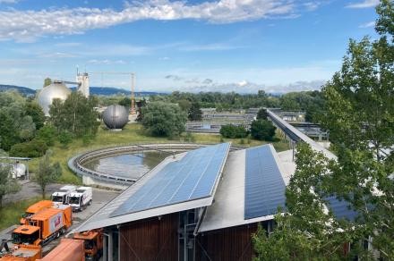 Blick auf die Kläranlage mit Müllfahrzeugen und PV Modulen.