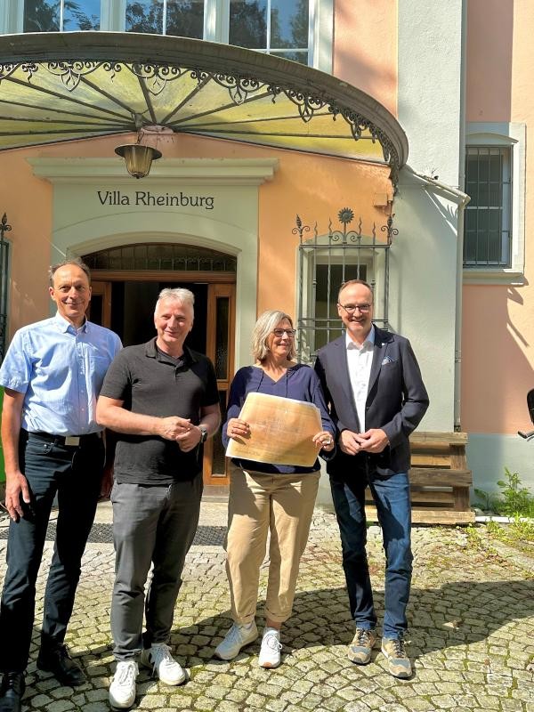 Vier Personen vor einem mit Glas überdachten Hauseingang