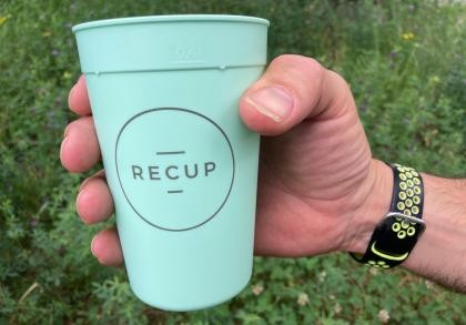 Eine Hand hält ein Recup-Becher
