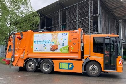 E-Müllfahrzeug mit bunter Beklebung