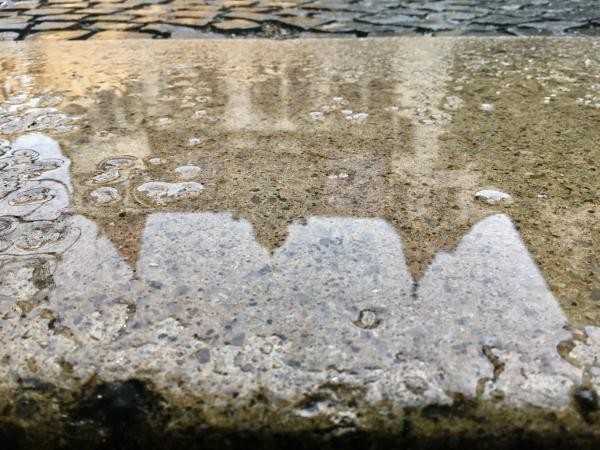 Pfütze mit Spiegelung des Konstanzer Rathauses