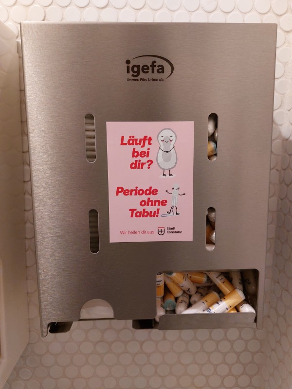 Sticker auf Spender mit Hinweis auf kostenlose Menstruationsartikel