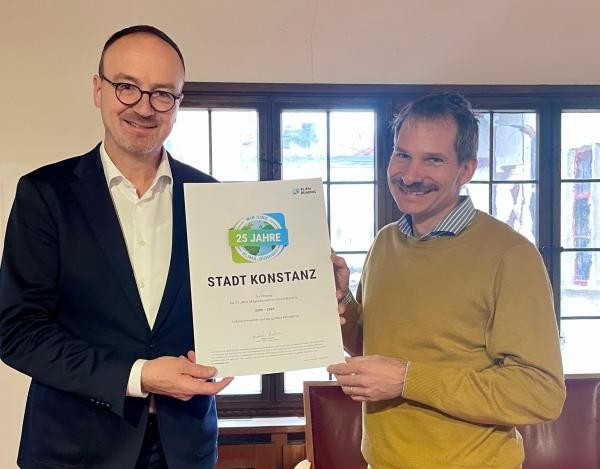 Zwei Männer halten eine Urkunde in den Händen