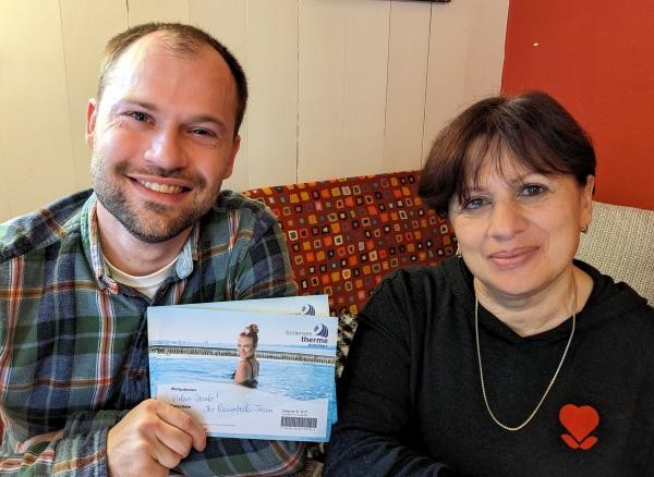 Ein Mann und eine Frau. Er hält Gutscheinkarten in der Hand.