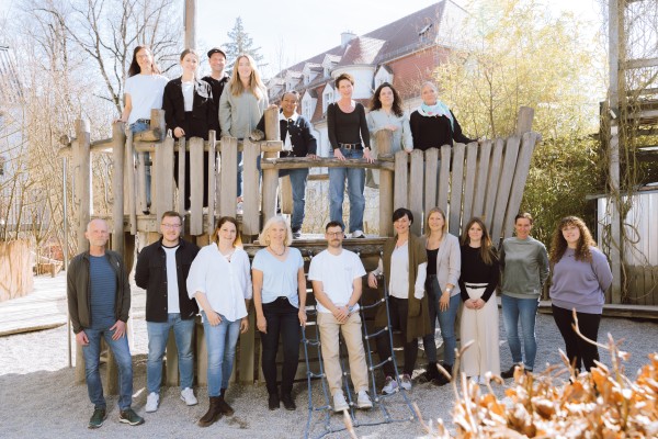 Erwachsene vor und auf einem Kletterturm