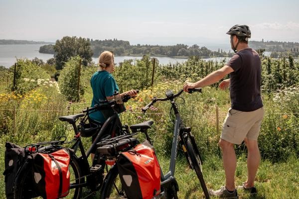 Zwei Radfahrer blilcken auf die Insel Mainau