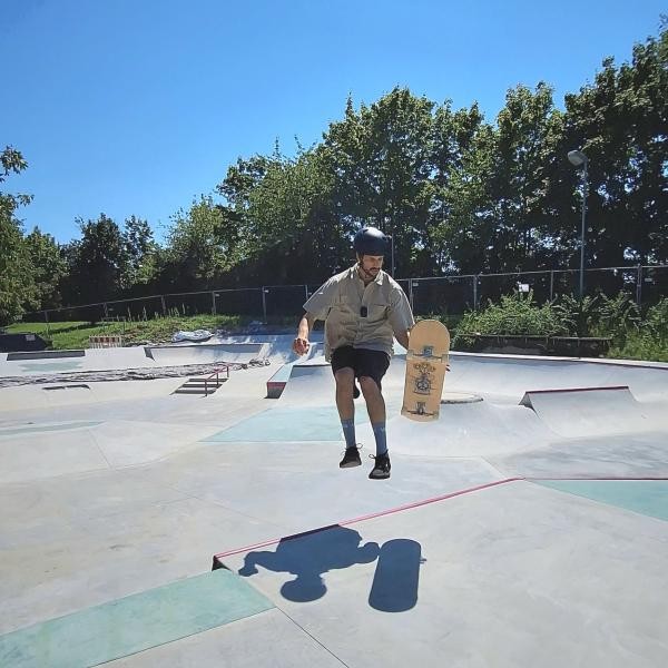 Copyright Stadt Konstanz Ein Bild eines Skaters der mit Skateboard in der Hand springt. Dahinter ein Skatepark mit Rampen