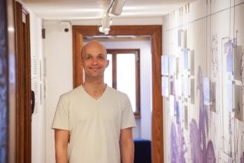 Mann in einem Flur neben einer Ausstellungswand