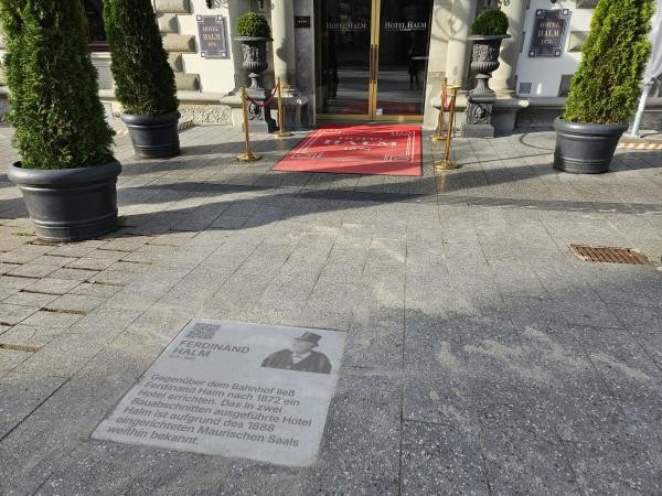 Vor dem Haupteingang des Hotel Halm erinnert #KonstanzErzählt an seinen Gründer Ferdinand Halm, den viele in Konstanz liebevoll „Papa Halm“ nannten. Mit dem Bau seines Hotels gegenüber dem Bahnhof wagte er in den 1870er-Jahren ein visionäres Projekt – und schuf ein Haus, das schnell über die Stadt hinaus bekannt wurde. Besonders der prachtvolle Maurische Saal machte das Hotel zu einer Sehenswürdigkeit.