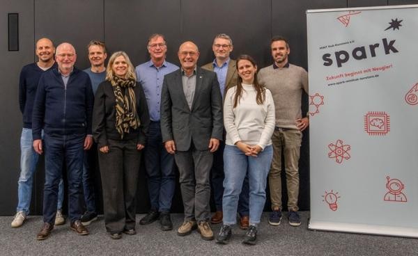 Personen stehend neben einem Rollup mit Schriftzug spark