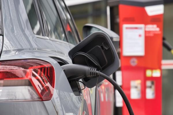 Ein silbernes Auto mit eingestecktem Ladekabel