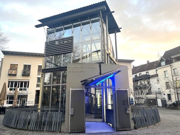 Eine Glasfassade mit blau beleuchtetem Eingang