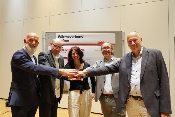 Fünf Menschen legen die Hände aufeinander.