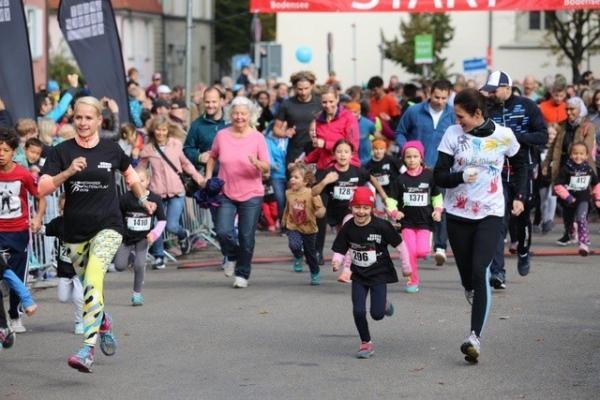 Kinder und Erwachsene mit Startnummern bei einem Stadtlauf