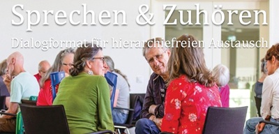 Mehrere Menschen sitzen in Gruppen und unterhalten sich.
