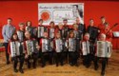 Bild des Konstanzer Akkordeon Ensembles mit ihren Instrumenten, positioniert in zwei Reihen. Alle Musiker sehen in die Kamera.